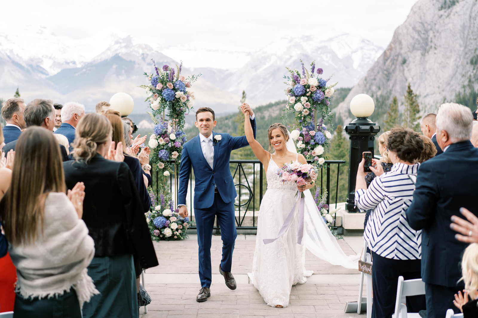 Newlywed recessional at Banff Springs wedding ceremony with blue purple pink flowers decor